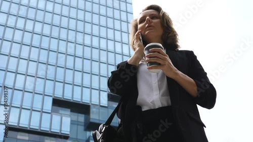 Businesswoman Speaking On The Phone Outdoors Near Office Building. Slow Motion.  photo