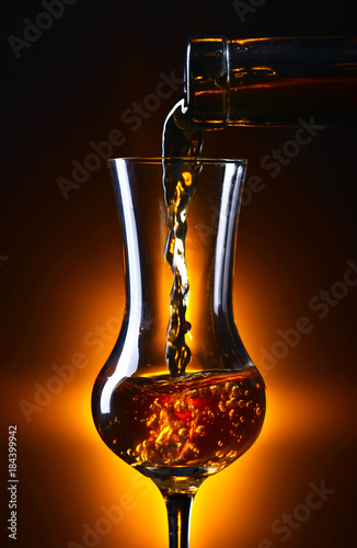 Foto Pouring alcohol drink into a wineglass .