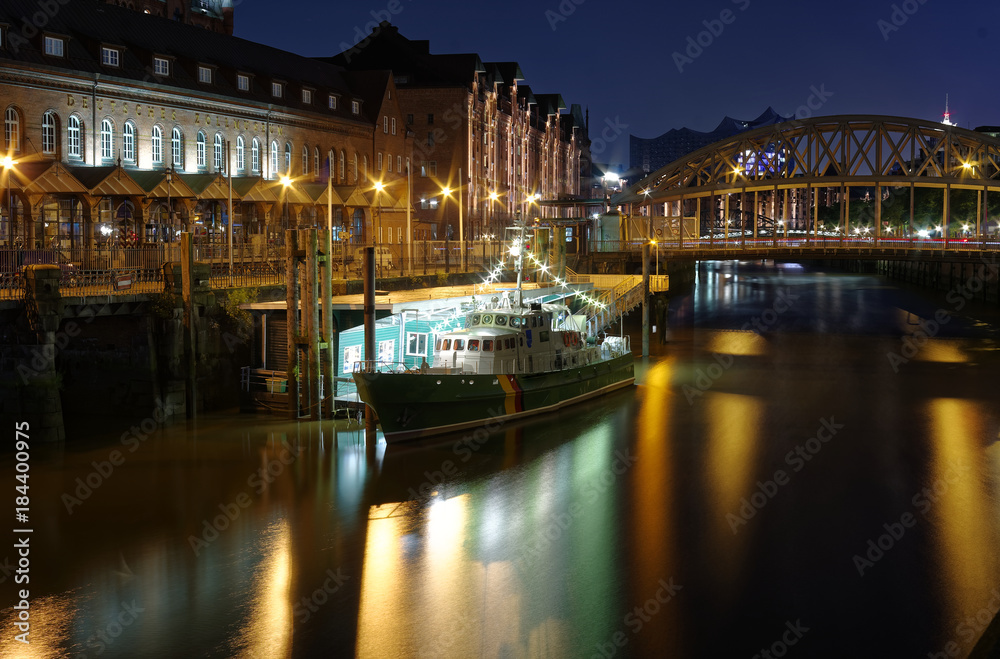 Hamburg Zollkanal mit historischem Zollboot und Brücke im Hintergrund bei Nacht