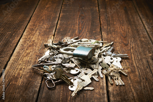 check-lock and group of different keys on wooden background with copy space. Concept of lost keys 