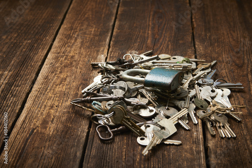 check-lock and group of different keys on wooden background with copy space. Concept of lost keys 