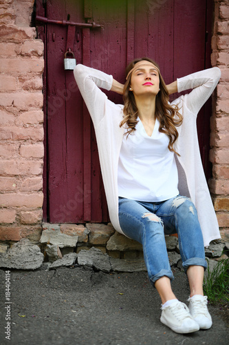 Resting woman teenage hippie stylish sitting in beautiful place street lifestyle momet photo
