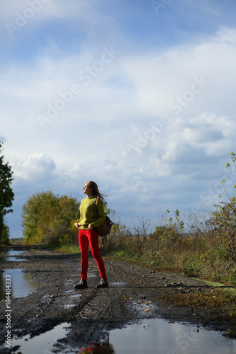 Woman walking on nature, forest, rural road, puddles, autumn, outdoor, blue sky