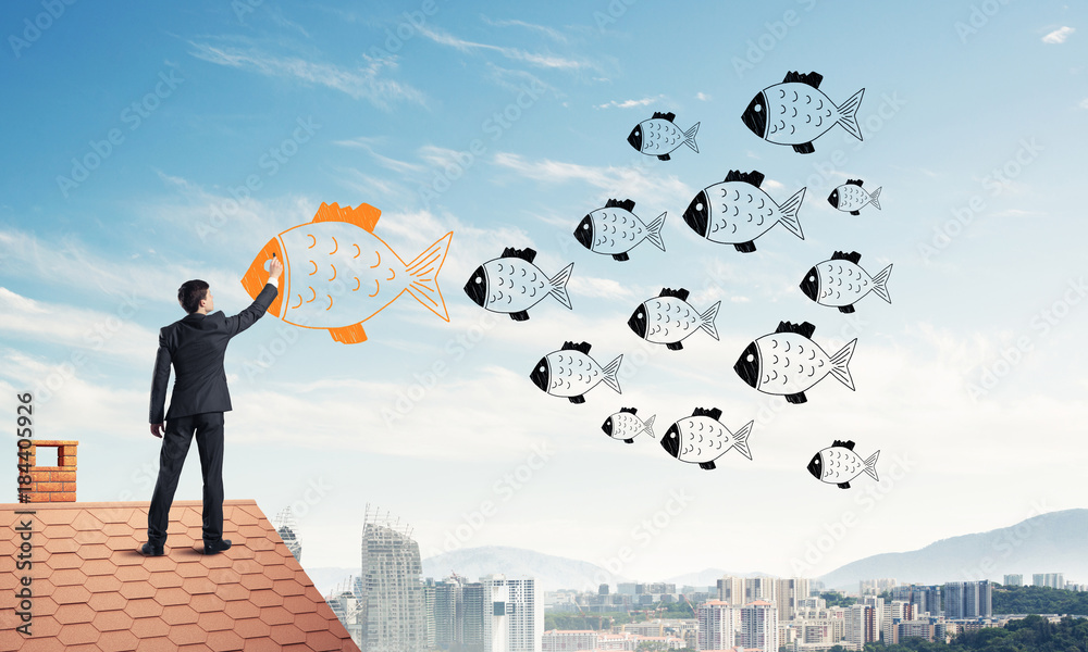 Businessman standing with back on house brick roof and drawing. 