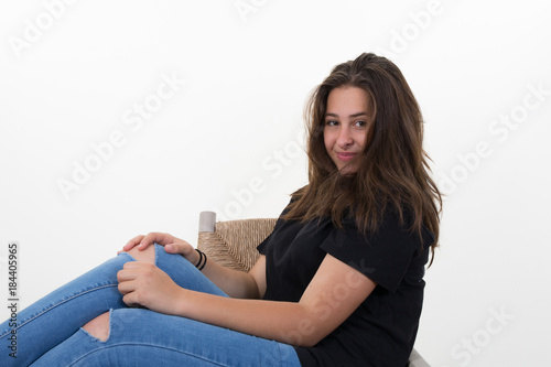 teenage brunette girl sitting crooked on a chair