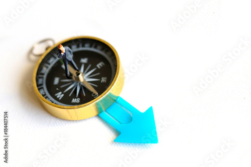 Miniature people   business man  on compass with color arrow