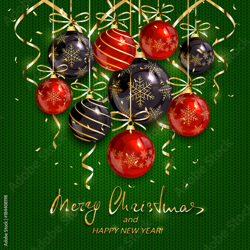 Red and black Christmas balls and golden streamers on green knitted background