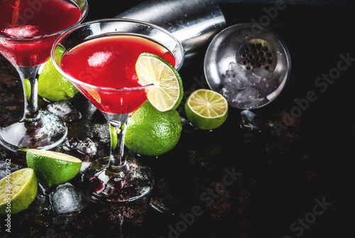 Red cosmopolitan cocktail with lime in martini glass, on dark rusty background copy space photo