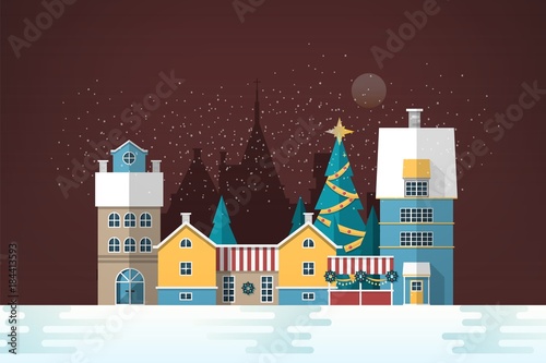 Snowy evening landscape with small European city. Cute houses and holiday str...