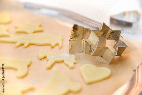 Ausgestochene Weihnachtsplätzchen vor dem Backen, mit Ausstechform photo