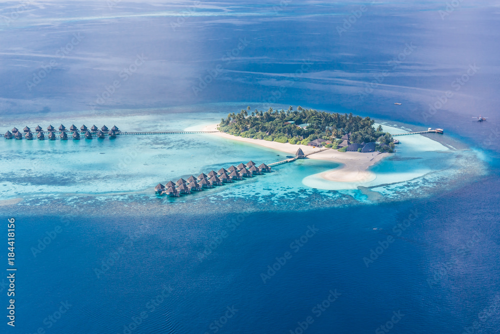 Maldives island aerial landscape view.  Beautiful blue sea and luxury water villas. Seaplane aerial view of Maldives atoll and coral reef