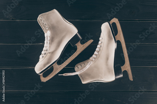 top view of pair of white skates on striped wooden surface