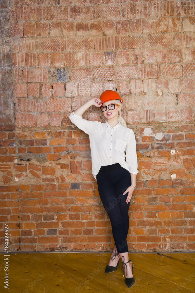Portrait of architect student or painter with blueprints protect helmet wearing. Brick red background. Portrait of architect student or painter with blueprints protect helmet wearing. Brick red background.