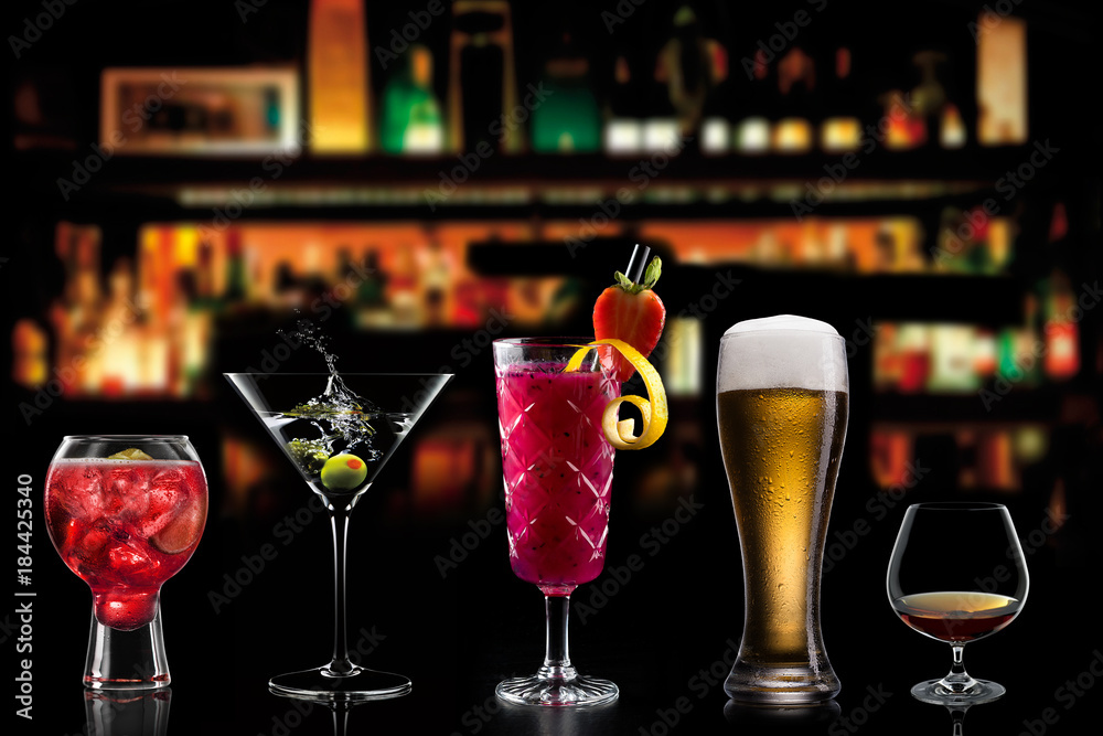 Selection of cocktails martini spritz bramble gin tonic beer bramble bar blurred black background