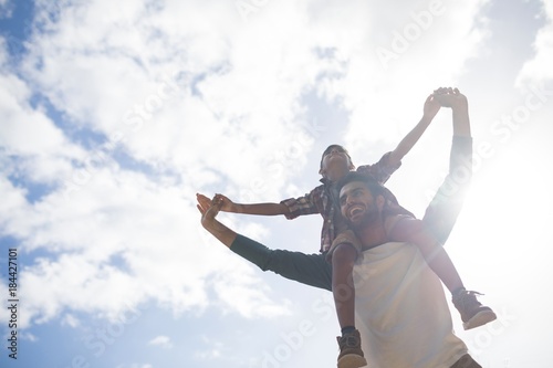 Fotografie Low angle view of happy father carrying son on shoulder