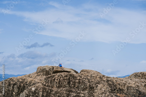 Female and man on the edge of the rock look on the monasteries of Meteora. Meteora in Greece in Thessaly at the early morning © flowertiare