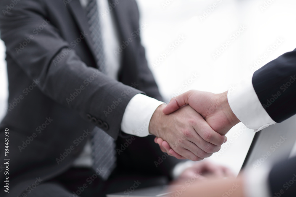 Closeup of business people shaking hands over a deal