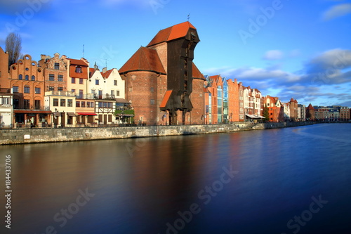Gdańsk, Polska, Wielki Żuraw i budynki nabrzeża Motławy, długie naświetlanie, błękitne niebo