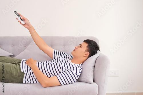 Man relaxing on sofa watching television photo