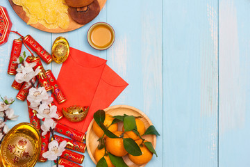 Lunar new year.Firecrackers and Chinese gold ingots and Traditional Red envelopes and decoration with Fresh oranges on wooden background