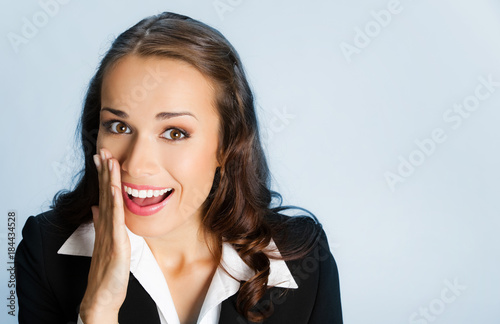 Business woman covering mouth, over blue
