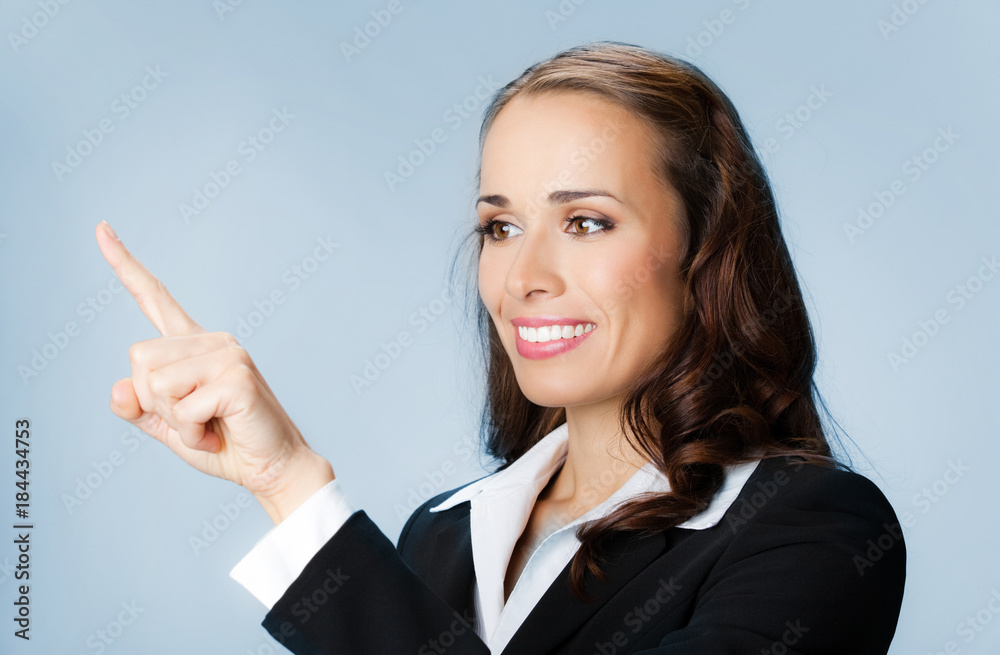 Businesswoman showing blank area for sign or copyspase, over blue Businesswoman showing blank area for sign or copyspase, over blue