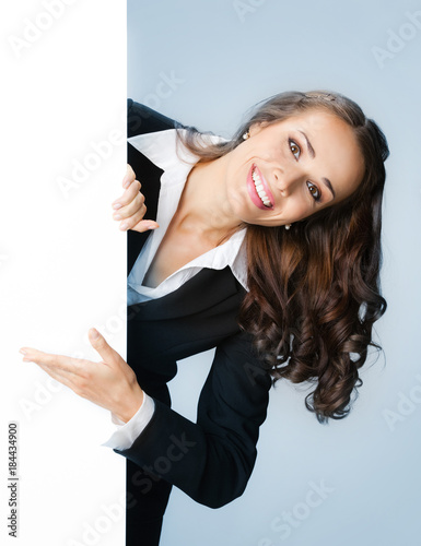 Businesswoman showing signboard, over blue