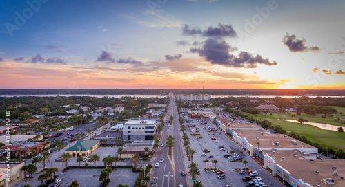 Aerial view looking down the road going through a town at sunset