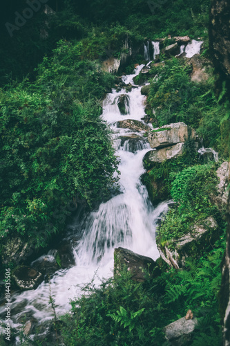 amazing waterfall with rocks and green plants in indian himalayas
