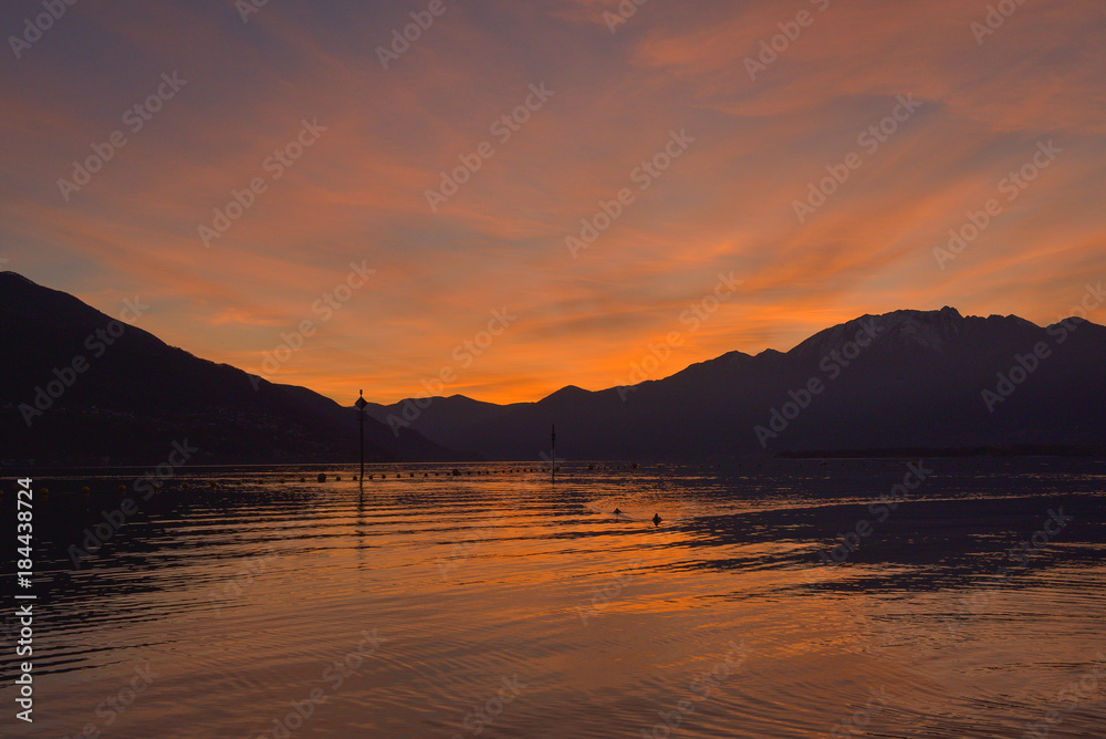 Tramonto sul lago con cielo colorato di rosa e arancione