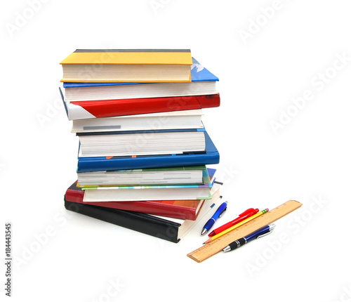 back to school: stack of books with ruler and pen on white background