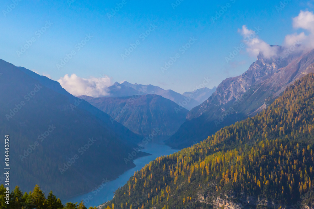 Fototapeta premium lago di Livigno lake with blue sky mountain landscape, spruce forest