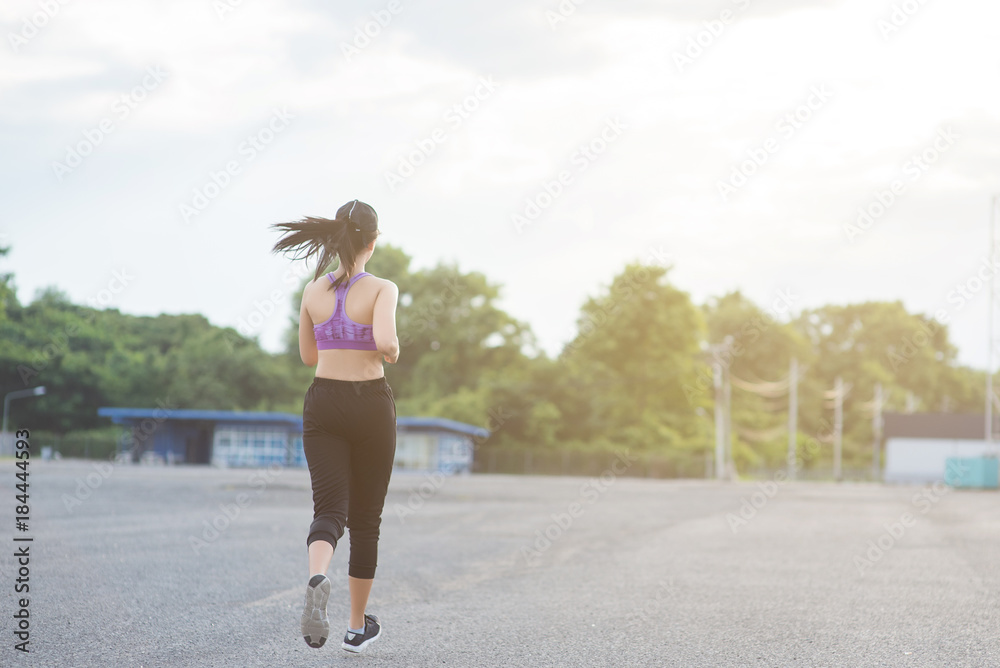 Young woman runner is jogging on the street be running for exercise. Selective focus