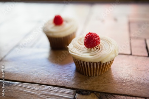 Close up of raspberry cupcakes on wooden table