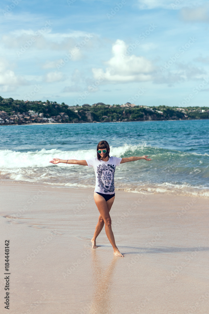 Beautiful young woman in sunglasses posing on the beach of a tropical island of Bali, Indonesia. Beautiful young woman in sunglasses posing on the beach of a tropical island of Bali, Indonesia.