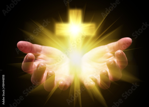 Obraz na plátně Hands cupped and holding or showing Cross or Crucifix with bright, glowing, shining light
