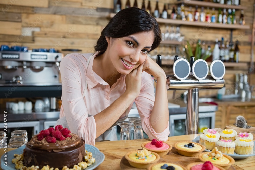 Portrait of waitress leaning at counter