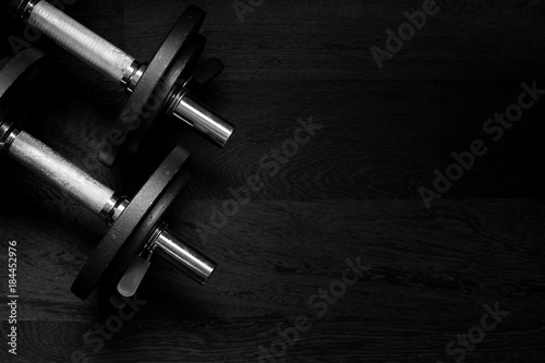 Black metal weights on wooden background, high contrast dark toned image