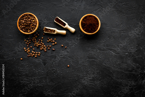 Coffee background. Roasted beans and ground coffee in bowls and scoops on black table top view copyspace