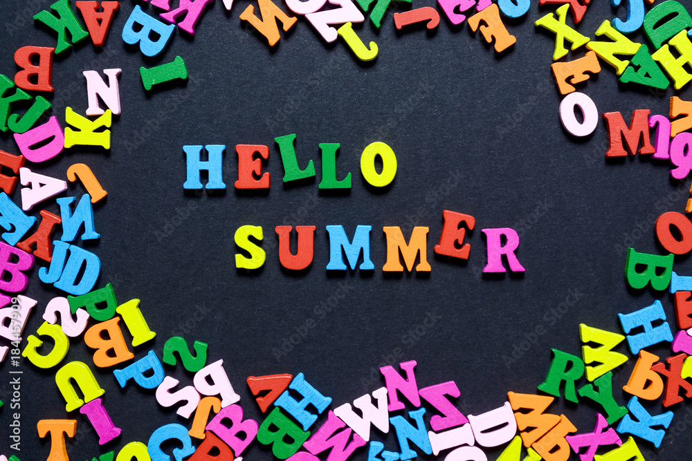 concept design - the word HELLO on SUMMER from multi-colored wooden letters on a black background, creative idea concept design - the word HELLO on SUMMER from multi-colored wooden letters on a black background, creative idea