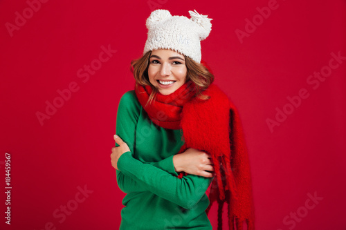 Smiling brunette woman in sweater, funny hat and scarf