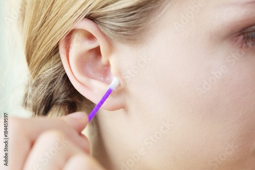 Woman cleaning ear with cotton swabs closeup © Voyagerix