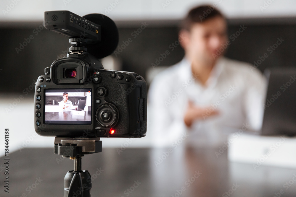 Handsome young man filming his video blog