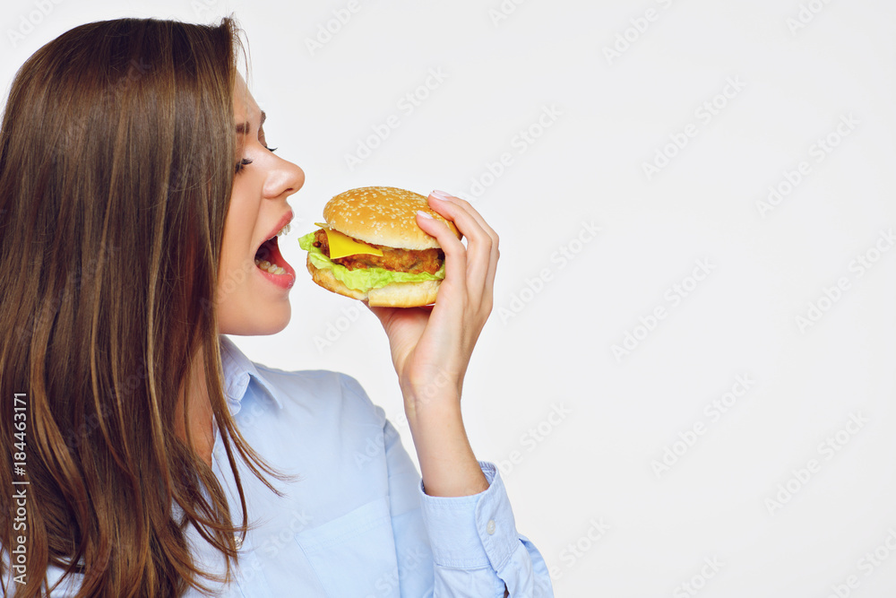 Portrait of young woman eating fast food burger. Portrait of young woman eating fast food burger.