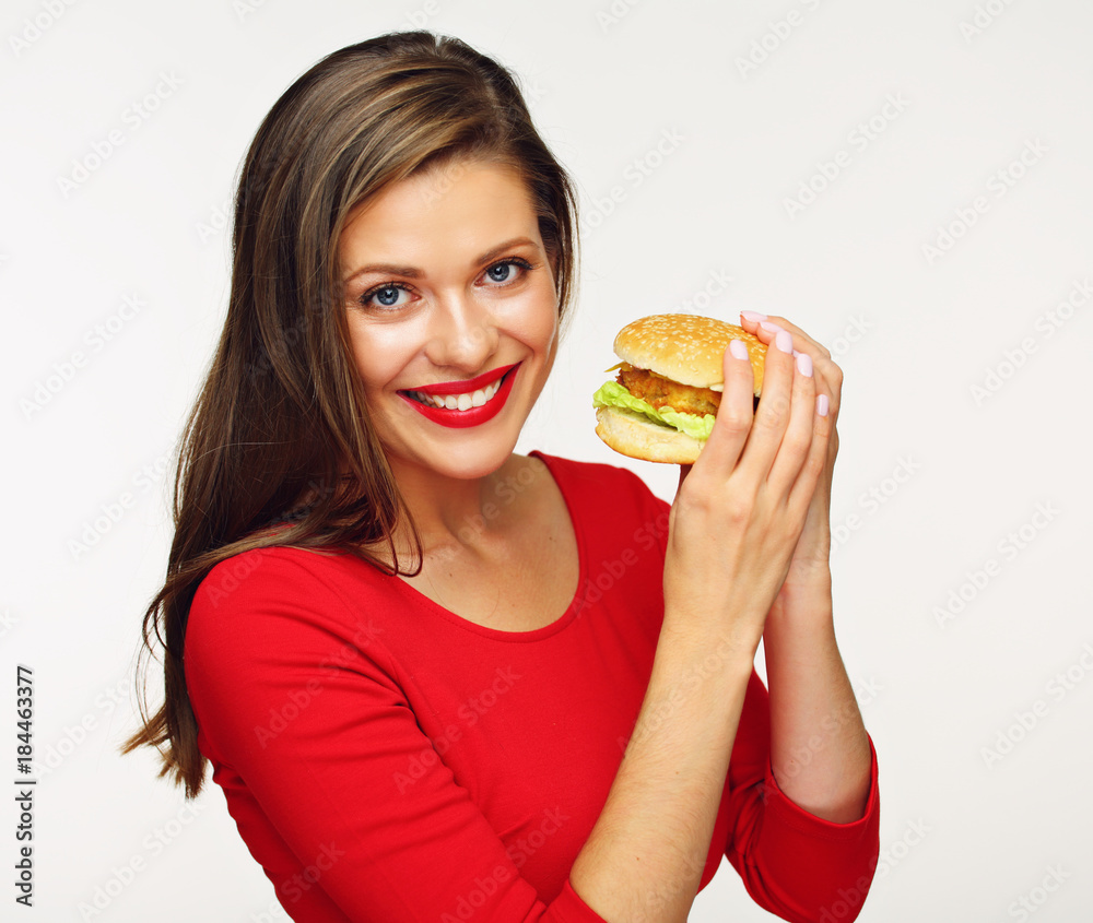 Smiling woman wearing red dress eating fast food burger. Smiling woman wearing red dress eating fast food burger.