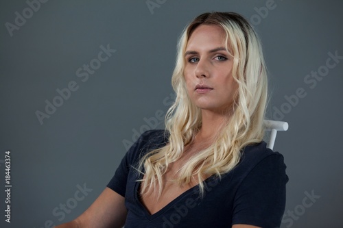 Portrait of beautiful transgender woman sitting on chair