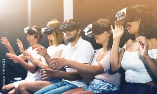 scared girl on virtual reality attraction sitting with another people photo