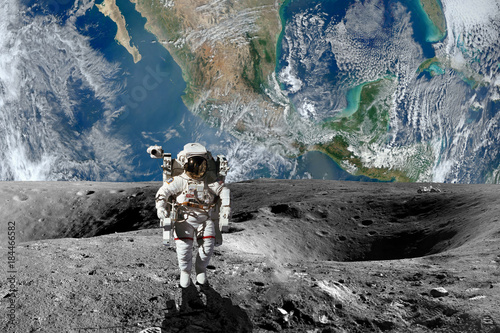 Astronaut on the Moon. Planet earth in background. Elements of this image furnished by NASA