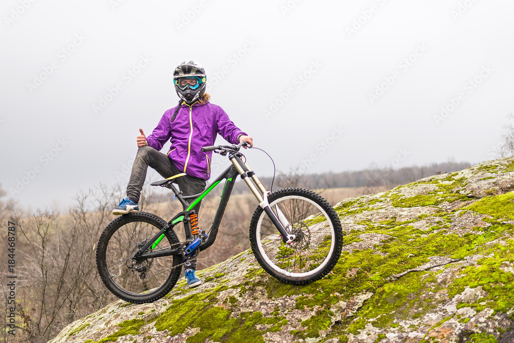 Cyclist holding a mountain bike on top of the free space.