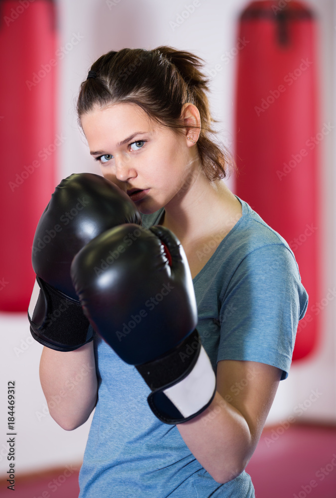 serious sportwoman in the boxing hall practicing boxing punches
